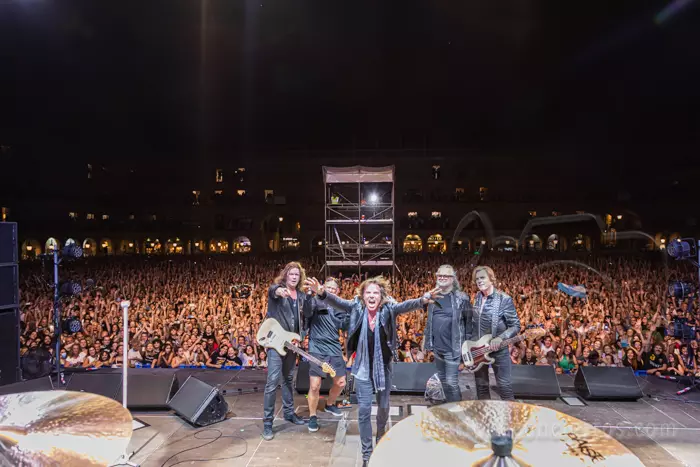 La banda de rock Europe saludando al público desde el escenario en una Plaza Mayor de Salamanca abarrotada durante las Ferias de la Virgen de la Vega.