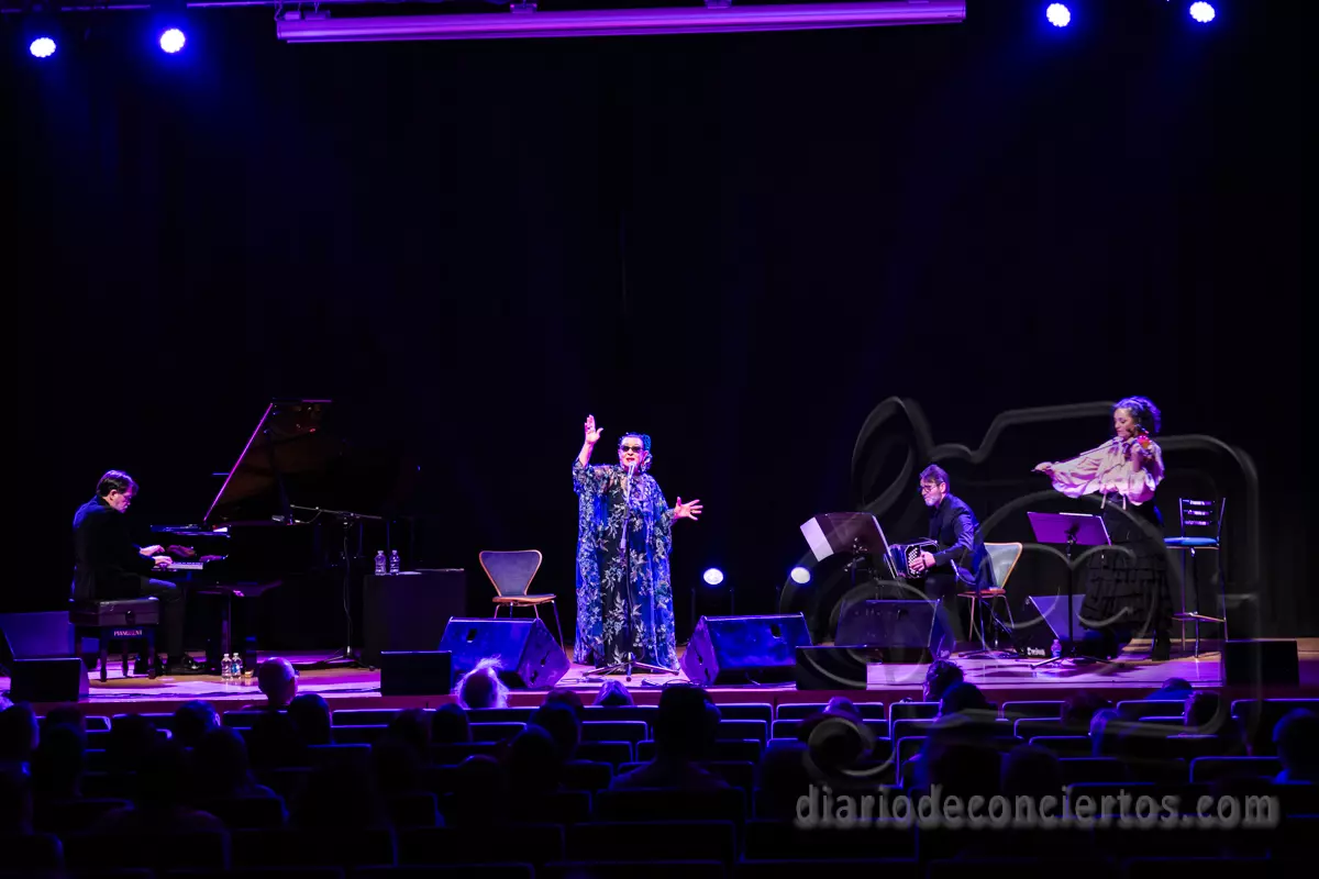 Escenario del Palacio de Congresos de Salamanca con Martirio cantando con los brazos abiertos, junto a un pianista, un bandoneonista y una violinista en plena ejecución.